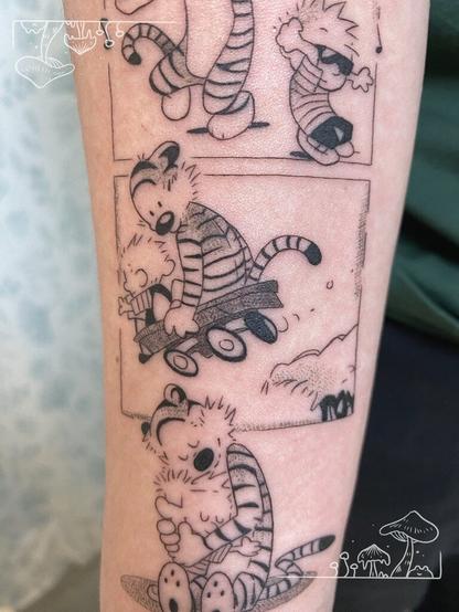 An arm tattoo depicting a panel from Calvin and Hobbes with the characters riding a small wagon downhill