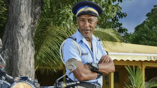 Danny John-Jules als Officer Dwayne Myers in Saint Marie auf seinem Motorrad Royal Enfield Bullet 500