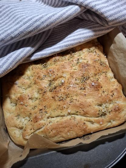 Yrttinen focaccia-leipä harmaaraidallisen keittiöliinan alla