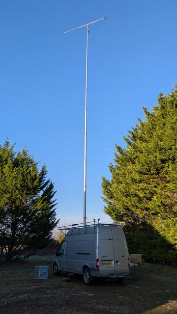 Silver portable radio van with a 20m mast and 70cm yagi on top