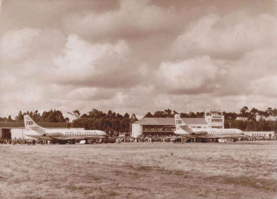 Sepia tones photograph of two jets sitting while large crowds look on