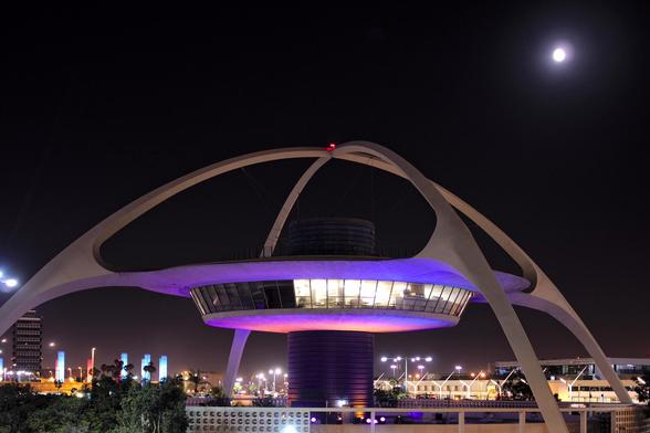 A futuristic, spider-like structure with a central tower and curved arches, known as the Theme Building at Los Angeles International Airport.