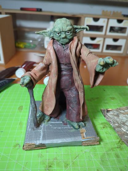 Verschiedene Ansichten einer selbstgemachten Figur von Meister Yoda. Die Figur ist aus sculpey und angemalt. 
Yoda steht da, eine Hand nach vorne gestreckt, die andere auf seinem Stock abgestürzt