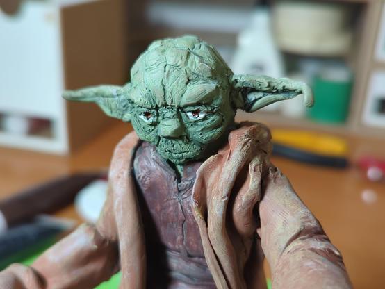 Verschiedene Ansichten einer selbstgemachten Figur von Meister Yoda. Die Figur ist aus sculpey und angemalt. 
Yoda steht da, eine Hand nach vorne gestreckt, die andere auf seinem Stock abgestürzt