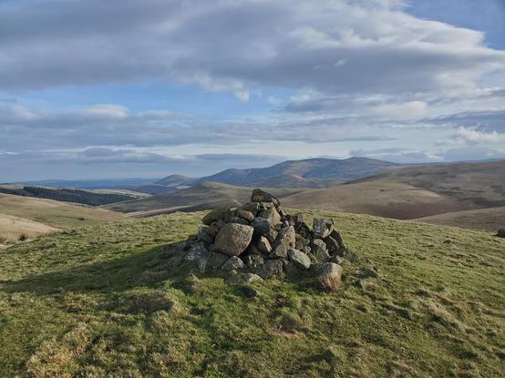 Eccles Cairn, near the border, another pile of rocks on a grassy hill with more Cheviot hills behind