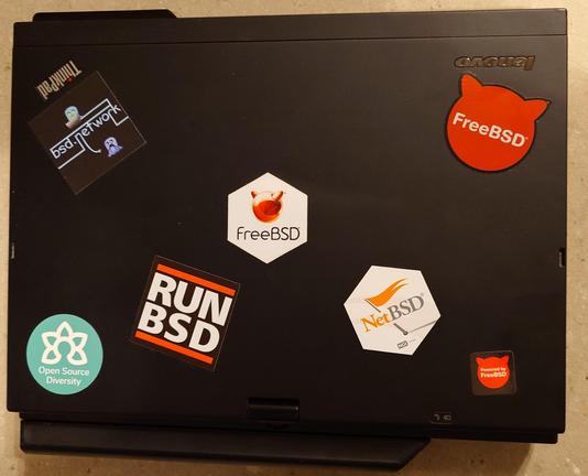 Lenovo ThinkPad laptop covered with BSD stickers