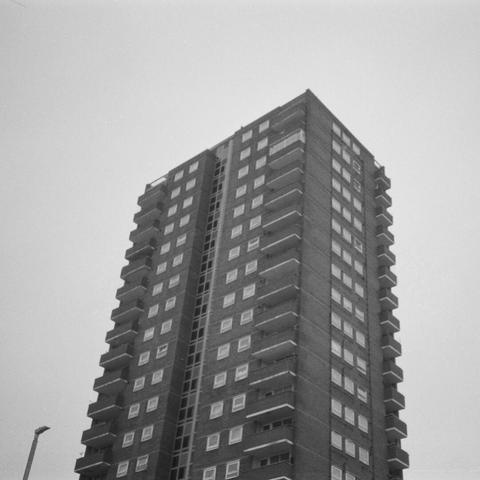 A 1960s style tower block straight up the middle of the black and white photo