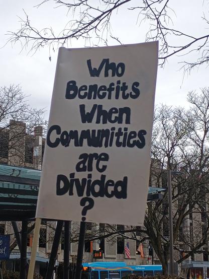 Sign that reads:
Who benefits when communities are divided?