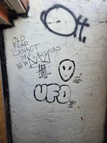 Graffiti that says 'old fear cannot see new things', has an alien head and says 'ufo'
