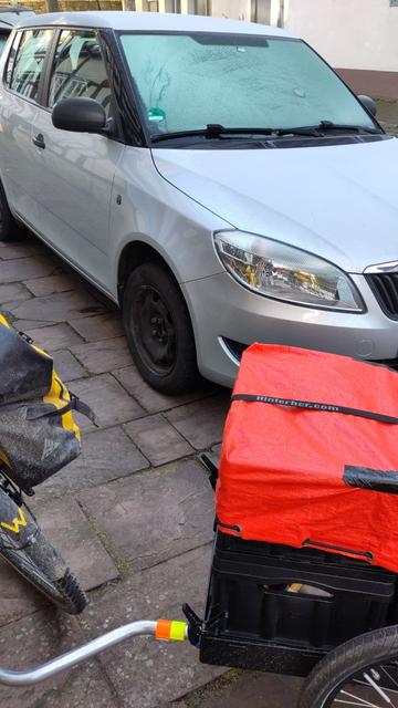 Fahrradanhänger vor Auto mit befrorener Windschutzscheibe