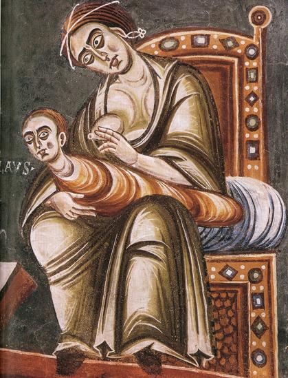 Romanesque fresco. A woman in long gown, sitting on throne (or at least heavily decorated chair), one breast bared. Worm-like, elongated creature on her knees is probably just a child, tightly wrapped, only neck and head visible. The child seems to turn its head away from the breast. Near the head – letters AVS