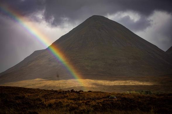 It's a photo taken in Sligachan, a village in Scotland. You can see a nice rainbow with a dark cloudy sky and in the back the mountain Cuillin