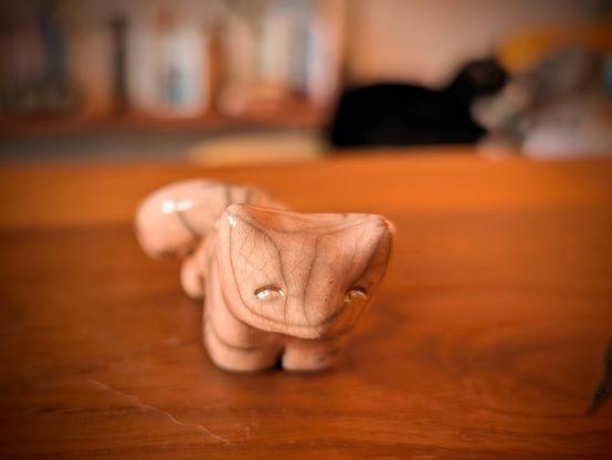 Un petit chat en raku beige avec des yeux qui sourient comme ça : ^^