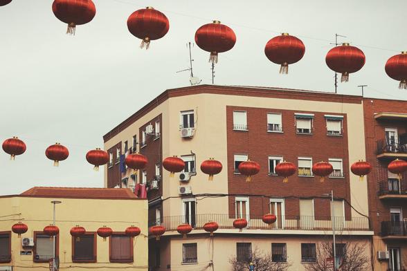 Edificios de los años 50 en una plaza con hileras de farolillos chinos