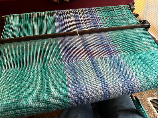 A blue and green cloth on the loom. It looks like all the other photos Jonobie has taken of this scarf in progress, but presumably she keeps doing it because she’s pleased with it.