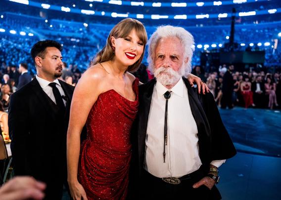 Taylor Swift in a red dress and Bob Weir in a suit at the Grammy Awards in 2025