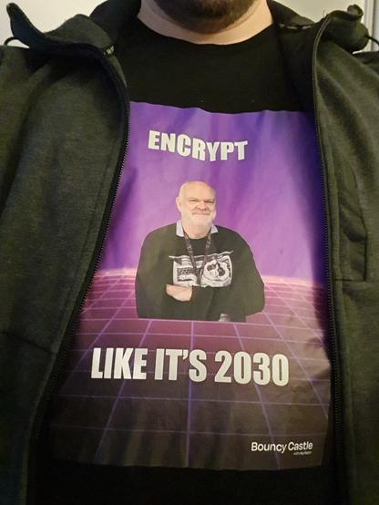 Person wearing t-shirt under hoodie with text ENCRYPT LIKE IT'S 2030 and a photo of David Hook. Bouncy Castle by Keyfactor
