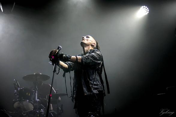 Le chanteur de Horskh au Bridge To Hell 2024 à Crest. les mains sur le micro, il regarde en l'air avec une certaine douceur, comme en transe.