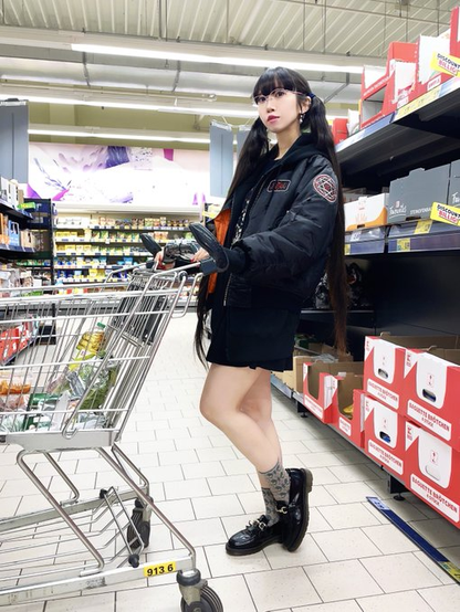 Hima in jacket at supermarket with cart
