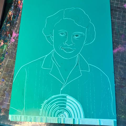 A green vinyl block as I begin carving. There’s an outline of a short haired woman in a short sleeve button down shirt, from shoulders up,looking forward at the viewer. Along the base there’s a strip with sporadic vertical stripes (which will be a stellar absorption spectrum). In the lower middle above the spectrum there a collection of nested semicircular lines.