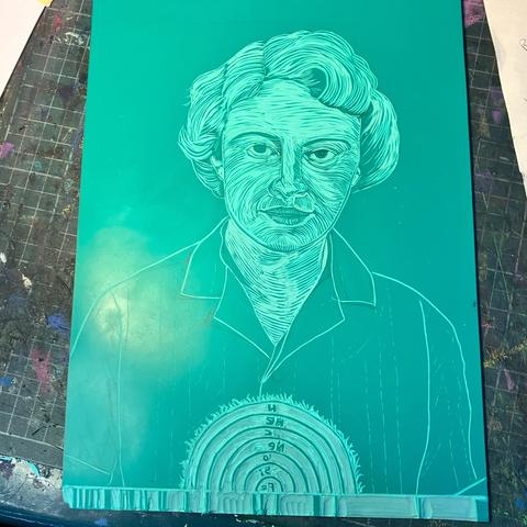 A green vinyl block as my carving proceeds. There’s an outline of a short haired woman in a short sleeve button down shirt, from shoulders up, looking forward at the viewer. Now her face, hair and neck have been carved. Along the base there’s a strip with sporadic vertical stripes (which will be a stellar absorption spectrum). In the lower middle above the spectrum there a collection of nested semicircular lines. Now it is clear that this is a diagram of a cross section of a red giant star. The outer most ring has flares radiating out. The rings are labelled (in reverse) from the centre out: Fe, Si, O, Ne, C, He, H.