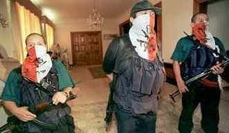 Nestor Cerpa Cartolini, the commander of the MRTA, flanked by two other members of MRTA. They are armed with machine guns, wearing flak jackets and bandanas covering their faces. https://mictlantecuhtli.tripod.com/politics/MRTA1i.html
