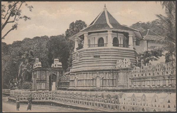 Printed monochrome postcard showing a view of the Temple of the Holy Tooth at Kandy in Ceylon.
Published by Plâté Ltd, Colombo, No 115, c.1910.
Postally unused.
Good condition, with very slight corner bumps and slight yellowing to top edge.