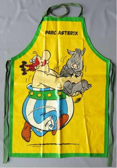 Gelbe Küchenschürze mit grünem Rand. Das Motiv ist Obelix, der ein Wildschwein trägt.