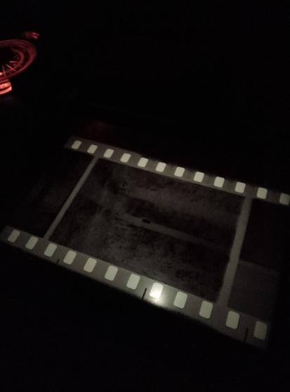 Labo foto a oscuras. Negativo 35mm en la ampliadora.