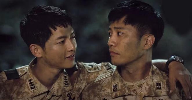 Big Boss and Wolf characters from Descendants Of The Sun k-drama are staring at each other. Big Boss has an arm around Wolf's shoulders