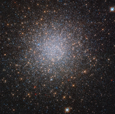 Hubble Space Telescope image of NGC 2419. The image shows a globular cluster with densely packed white, orange, and blue stars on a black background.