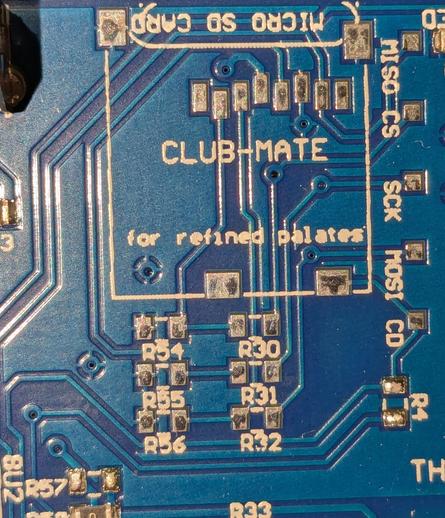 A close up of a circuit board with a square presumably for an unused micro SD card slot, but within the square it says 
"CLUB-MATE"

"for refined palates"