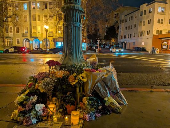 Photos of flowers arranged around a pole near with a view of the crosswalk in the background