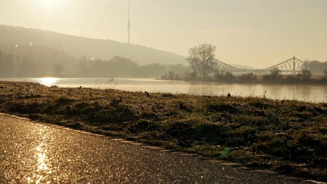 Elberadweg am Morgen, bei leichtem Frost
Sonne strahlt frontal ins Bild, der Asphalt glitzert, dir Elbe reflektiert und Brücke/Turm verschwinden halb im Nebel

Bild leicht bearbeitet