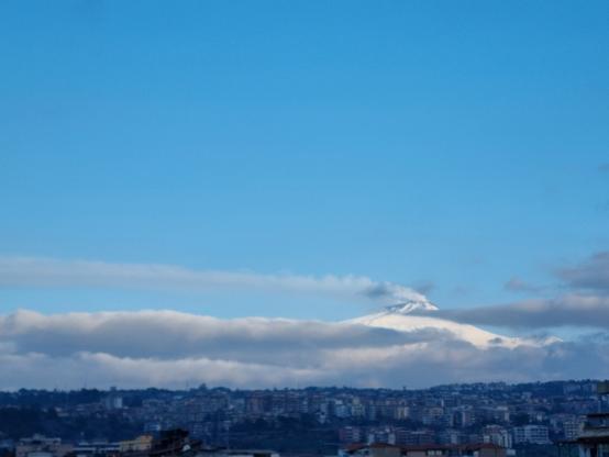 Etna ancora fumante, tra cielo rischiarito dopo le piogge della notte, qualche nuvola passeggera