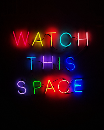 Neonletters in verschillende kleuren spellen Watch this space