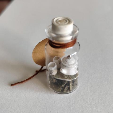 Miniaturka w małej butelce (10 ml). W srodku zestaw do herbaty wykonany z papieru. Czajniczek i dwie czarki.