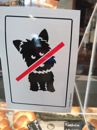 Piktogramm mit einem niedlichen flauschigen Hund der von einer roten Linie durchgestrichen wird.