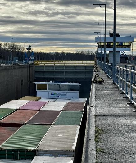 Ein Containerschiff wird in der wieder eröffneten rechten Kammer der Doppelschleuse Iffezheim zu Tal geschleust. Im Hintergrund ist das neue Obertor zu sehen.