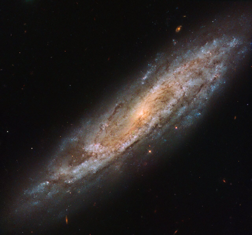 The galaxy NGC 2770 as imaged by the Hubble Space Telescope. The spiral galaxy's stars are seen somewhat edge-on from the bottom left to top right of the image on a black background.