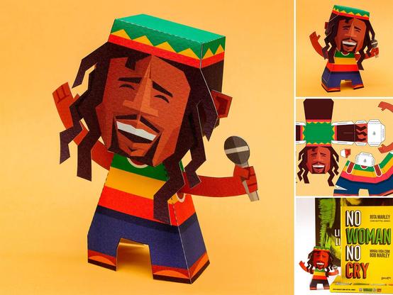 Paper figure of Bob Marley with dreadlocks and a beanie, holding a microphone. Side images show assembly instructions and packaging on a yellow background.