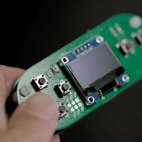 game console being held by finger tips showing small size but comfortable button positioning.