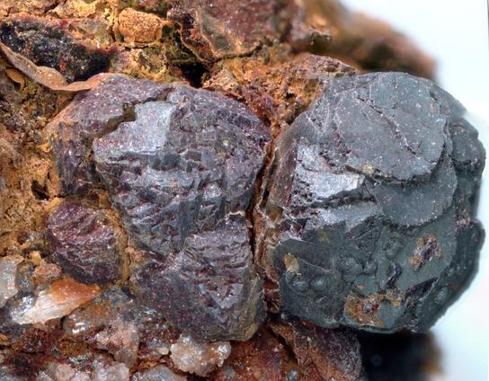 Two complex cuprite crystals, one on the right has a slightly more blue colour due to a coating of chrysocolla. Both on an orange 'limonite' matrix.