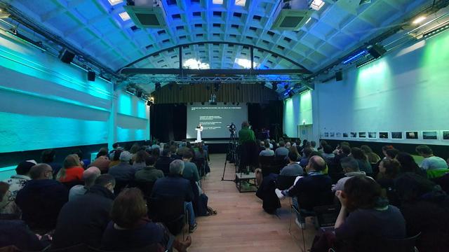 Une salle de conférence avec plein de gens présents