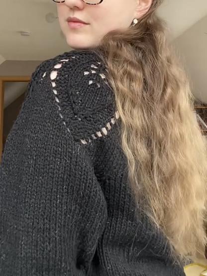 Mauni is looking over the shoulder to showcase the leaf pattern that drapes over the shoulder