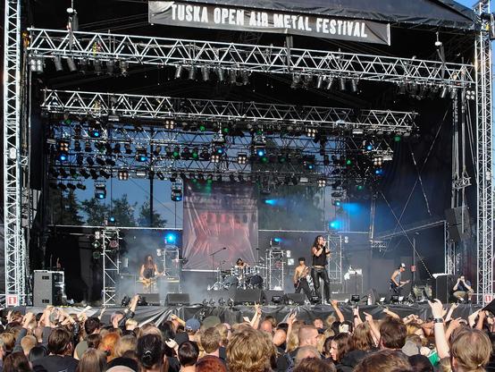 Death Angel esiintymässä Tuskan päälavalla 2004. Kuvassa koko lavarakenne ja sen yläpuolela lukee Tuska open air metal festival. Kuvan alalaidassa paljon yleisöä takaa päin nähtynä.