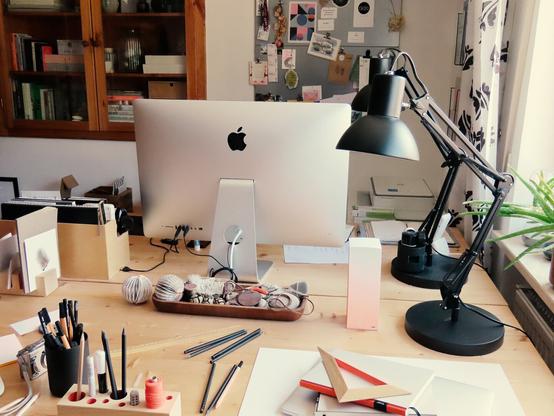 Büro mit 2 Schreibtischen, Lampen, Schreibutensilien und einem iMac.