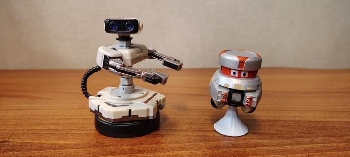 Photo of two toy robot figurines on a desk: ROB the Nintendo Entertainment System robot, and VINCENT the robot character from the 1979 film "The Black Hole."