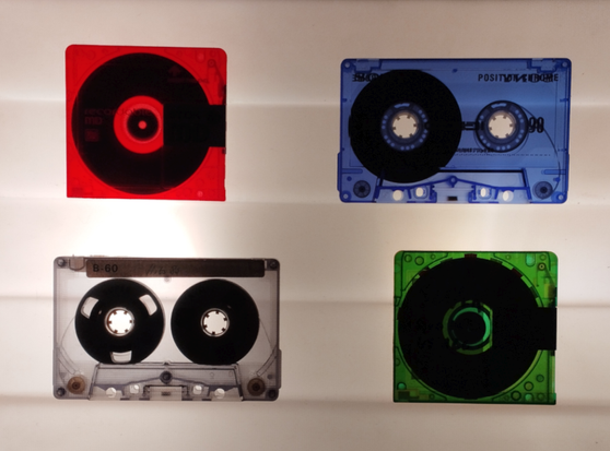 A lightbox for slides but instead of slides there a 4 clear MiniDisks and Tapes laying on it. 

From top right: A Red MD, blue cassette, clear tape, green MD