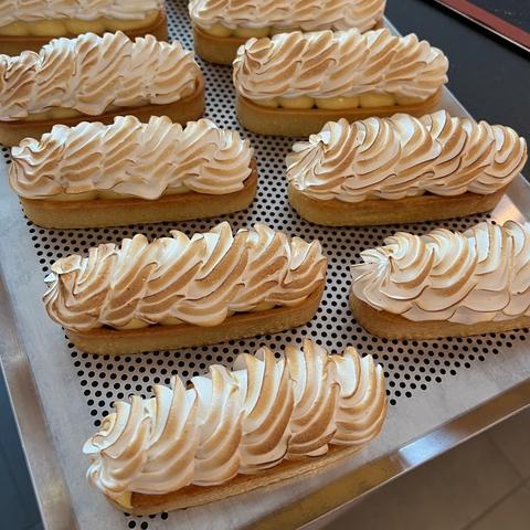 10 oblong tartlets with a spiral swirl of torched Italian meringue, on an aluminum tray